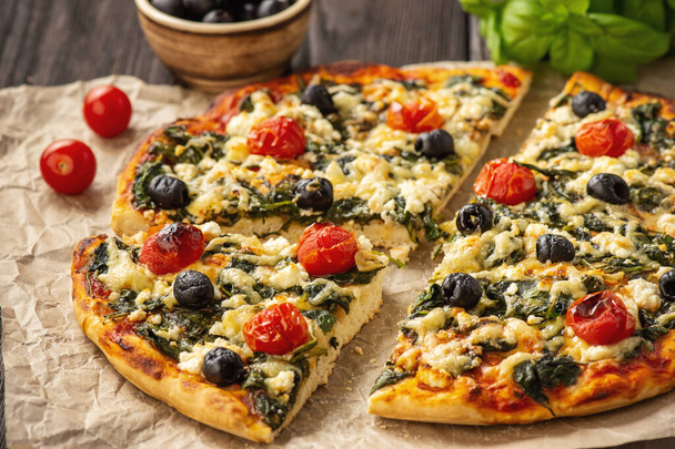 Homemade pizza with spinach, tomatoes and olives. - Valokuva, kuva