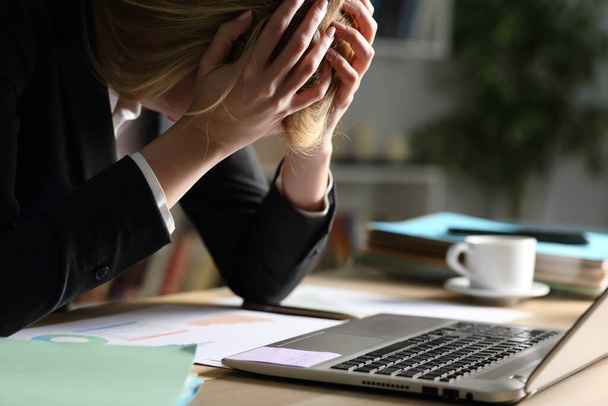 Großaufnahme einer traurigen Unternehmerin, die sich nachts am heimischen Schreibtisch über schlechte Ergebnisse beschwert - Foto, Bild