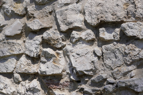 Πέτρινο τείχος, μεγάλες γκρίζες πέτρες, η αστική και βιομηχανική κατασκευή. - Φωτογραφία, εικόνα