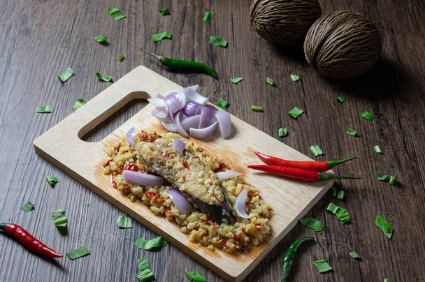 Parní solené King makrela ryby s mletým česnekem a chilli salátem na dřevěném pozadí. (Pikantní thajské jídlo volání Yum Pla Kem ) - Fotografie, Obrázek