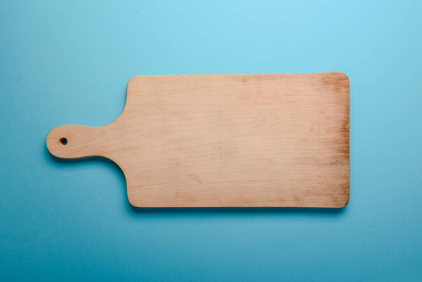 wooden cutting board on a blue background - Photo, Image