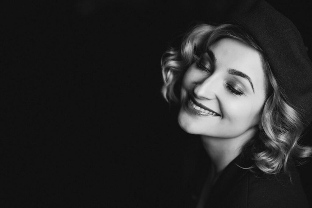 Beautiful blonde girl in a beret closed her eyes and smiles in retro style black and white photo. Close-up portrait. Soft focus. - Foto, immagini