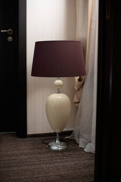 Un grand lampadaire sur le sol dans une pièce sombre. Design d'intérieur. Concentration sélective douce
. - Photo, image