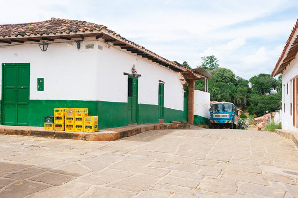 Barichara, Colombia, May 20, 2012: Street with green house and blue bus in Cartagena - Fotoğraf, Görsel