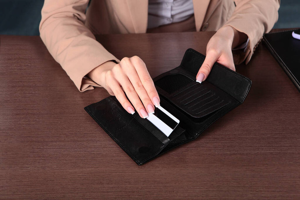 La femme prend une carte en plastique pour le paiement de son portefeuille. Photo méconnaissable. Vue du dessus
. - Photo, image