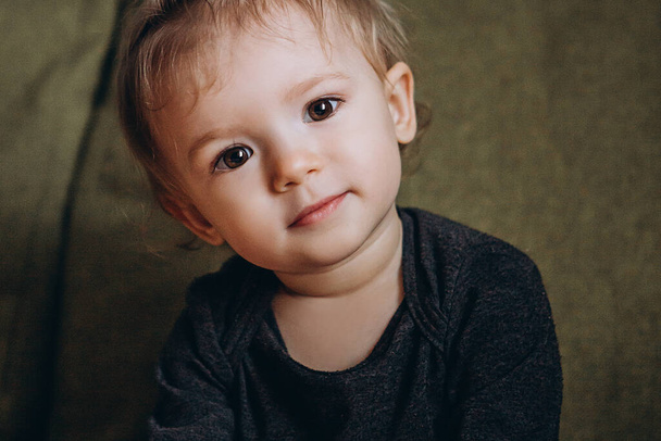 ritratto di carino bambino carismatico con un sorriso gentile in stile vintage, portato a casa nella nursery, stilizzato per la fotografia cinematografica domestica
 - Foto, immagini