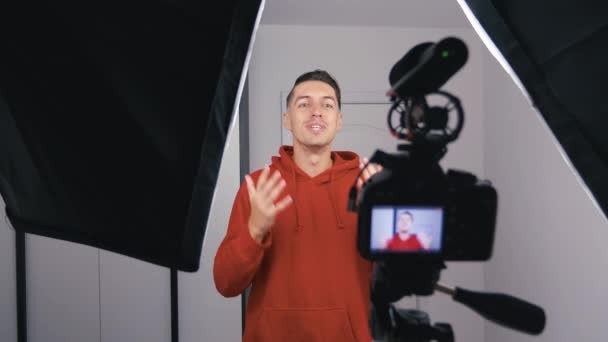 Felice giovane blogger uomo riprese nuovo video vlog con fotocamera professionale a casa
 - Filmati, video