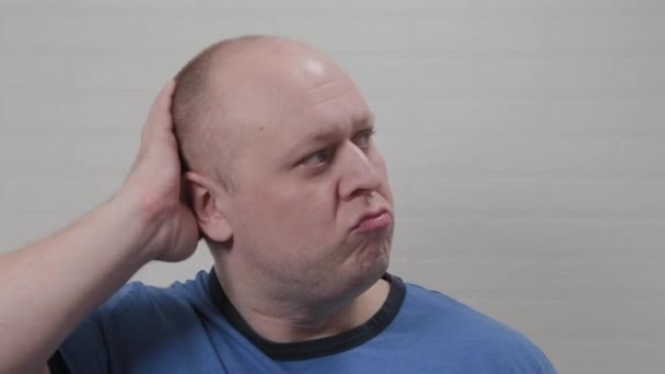 A bald man touches his bald head on camera. Portrait of a bald man. - Footage, Video