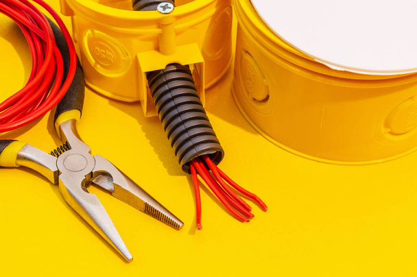 Peças sobressalentes e fios para substituição ou reparação de equipamento eléctrico sobre fundo amarelo
 - Foto, Imagem