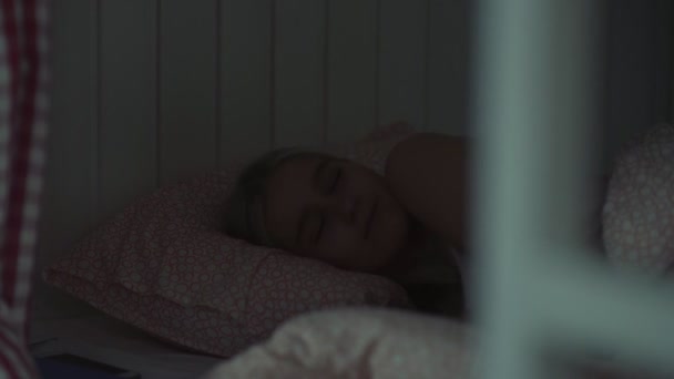 Młoda kobieta śpi w przytulnym pokoju hostel w nocy - Materiał filmowy, wideo