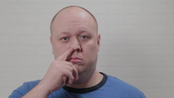 A bald man picks his nose at the camera. Portrait of a bald man. - Footage, Video