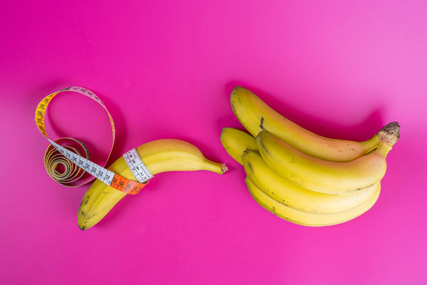 banana tape measure on fuchsia background - Φωτογραφία, εικόνα