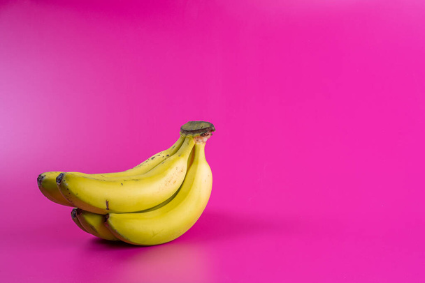 ripe yellow bananas on fuchsia background - Photo, Image