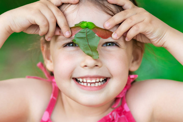 Κορίτσι 5 ετών. κρατώντας σπόρους σφενδάμου και πανηγυρίζοντας που το καλοκαίρι έχει έρθει - Φωτογραφία, εικόνα