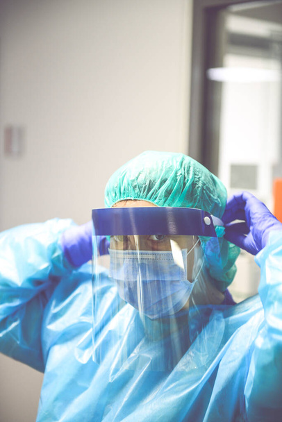 Doctor vistiendo bata desechable con máscara y google de seguridad en el hospital. Pandemia 2019 Coronavirus 2019-nCoV
. - Foto, imagen