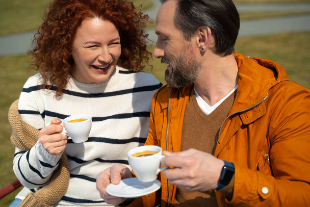 Beautiful married couple chatting and drinking coffee outdoors - Foto, afbeelding
