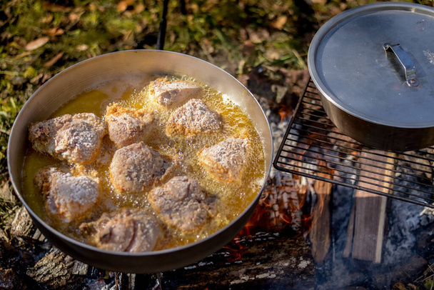 Cozinhar comida sobre fogo aberto enquanto acampar em uma aventura
 - Foto, Imagem