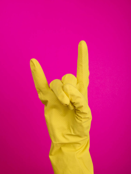  Hand in a latex glove isolated. A hand in a glove holds a sponge for washing and cleaning. Cleaning or housekeeping concept background. Frame for text or advertising. colorful background - Foto, immagini