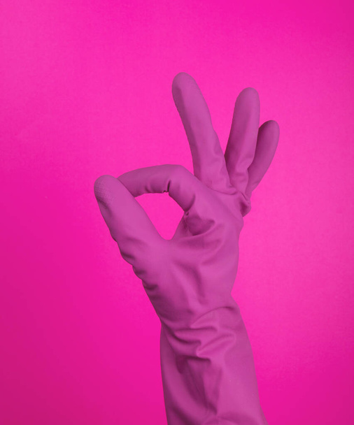 Hand in a latex glove isolated. A hand in a glove holds a sponge for washing and cleaning. Cleaning or housekeeping concept background. Frame for text or advertising. colorful background - 写真・画像
