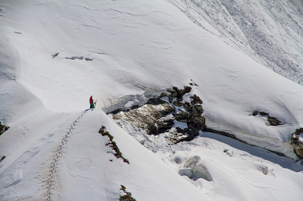Skier climbing a snowy mountain - Fotoğraf, Görsel