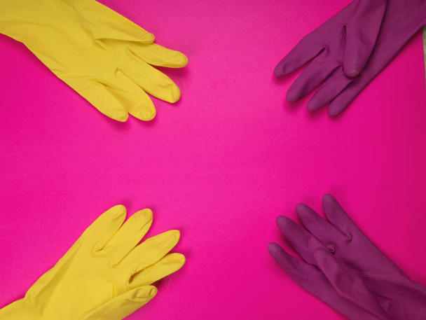 kolor gumowe rękawice do czyszczenia na różowym tle, koncepcja przytułku. Firma sprzątająca. Ręce pracownika w kolorze gumowej rękawicy ochronnej. Ogólne lub regularne sprzątanie.  - Zdjęcie, obraz
