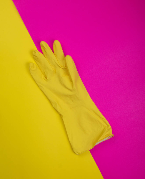 color rubber gloves for cleaning on pink background, workhouse concept. Commercial cleaning company. Employee hands in color rubber protective glove. General or regular cleanup.  - 写真・画像