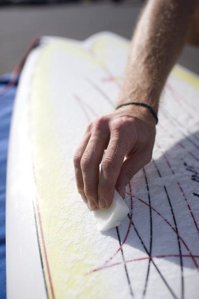 man waxing his surfboard. - Photo, Image