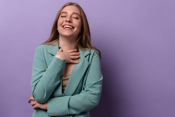 Photo of a happy optimistic woman laughing posing indoors isolated over purple wall background. - Fotoğraf, Görsel