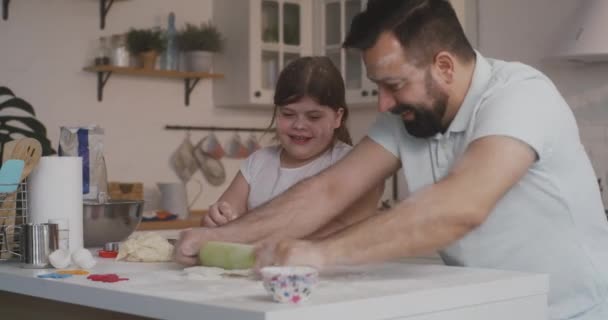 Vader en dochter maken samen cake. - Video