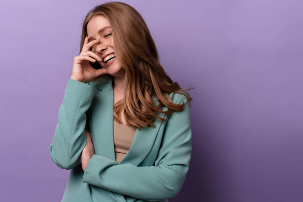 Image of a positive laughing woman posing indoors isolated over purple wall background. - Φωτογραφία, εικόνα