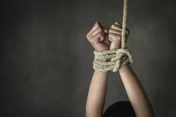 人身売買の犠牲者の行方不明者のロープで縛られた手。虐待と拷問の概念。女性に対する暴力を止めなさい。国際女性デー。暴力を乱用しないで. - 写真・画像