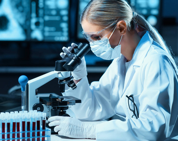 Scientist working in modern lab. Doctor making microbiology research. Laboratory tools: microscope, test tubes, equipment. Bacteriology, virology and health care concept. - Photo, Image