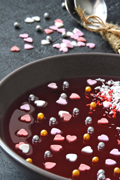 Breakfast or dessert for Valentine's Day. Red marmalade bowl with sweet hearts and decorations. Romantic healthy food. - 写真・画像