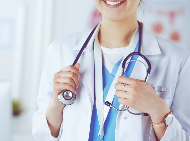 Portrait of young woman doctor with white coat standing in hospital - Foto, Bild