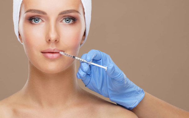 Doctor injecting in a beautiful face of a young woman. Plastic surgery, skin lifting and aesthetic medicine concept. - Valokuva, kuva