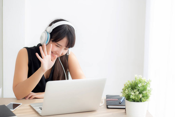 Piękny młody Asian kobieta nosić słuchawki uśmiechnięty powiedzieć cześć przy pomocy rozmowa wideo rozmowa u laptop rachmistrz, Dziewczyna rozluźnić cieszyć się słuchanie muzyki online, wykształcenie nauka, komunikacja i styl życia pojęcie. - Zdjęcie, obraz
