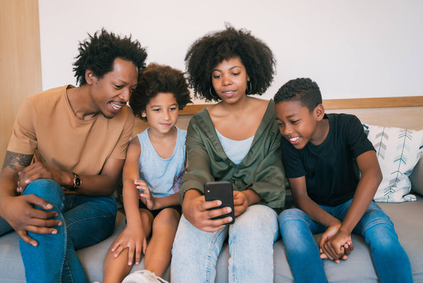 Portrait of African American family taking a selfie together with mobile phone at home. Family and lifestyle concept. - Zdjęcie, obraz