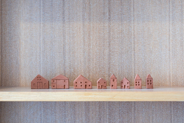 木製の棚室内の家やコピースペース付きの生活装飾建物のミニチュアモデルテラコッタの家。家族の不動産のコンセプト計画  - 写真・画像