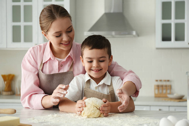 Mother and son cooking together in kitchen - Foto, imagen