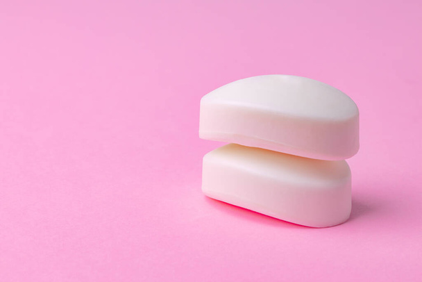 Soap bar isolated on pink background. Close up. - 写真・画像