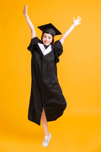 felice giovane donna in abiti di laurea ballare per la celebrazione
 - Foto, immagini