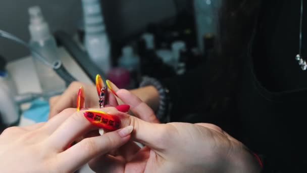 Faire de la manucure dans le salon de beauté - appliquer soigneusement le vernis à ongles rose sur un ongle naturel
 - Séquence, vidéo