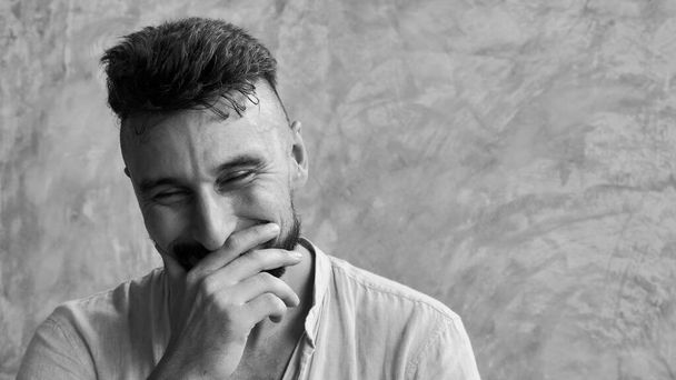 Portret van een vrolijke volwassen knappe man in de 30 die lacht en lacht. Binnenshuis - Foto, afbeelding