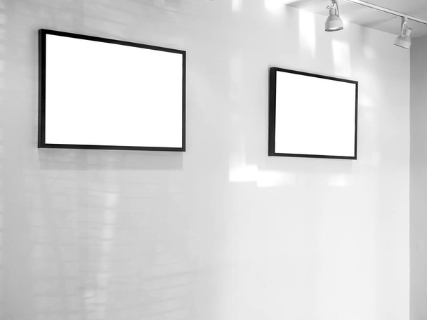 Két fehér üres keretek reflektorfényben fehér fal háttér művészeti galériában. - Fotó, kép