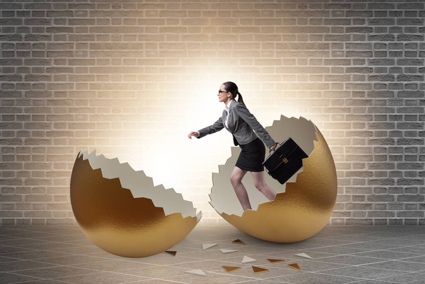 Businesswoman breaking out of golden egg - Photo, Image
