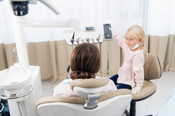 Little cute girl performing a dental check up of her doctor. Kid - Foto, Bild
