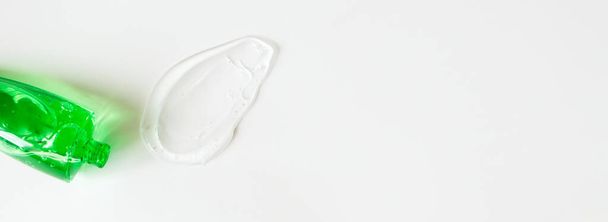 Aloe Gel Fleck und grüner Schlauch auf weißem Hintergrund mit Kopierraum. Reinheit Gesichtsreiniger, Peeling oder Shampoo horizontales Banner-Format - Foto, Bild