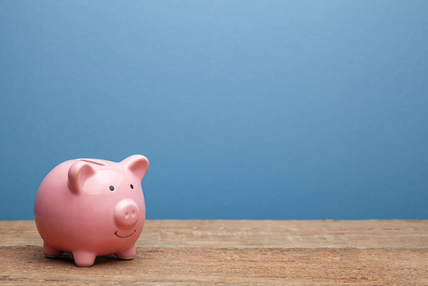 Pink piggy bank on a blue background. Copy space for text. - Foto, immagini