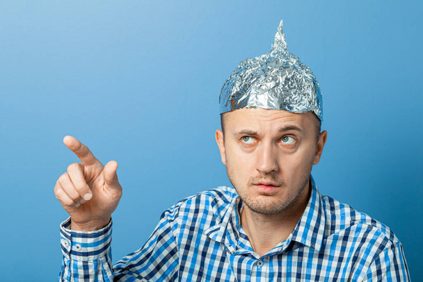 Foil hat on man. Man with a surprised face shows thumb up. Protects from reading think - Photo, Image