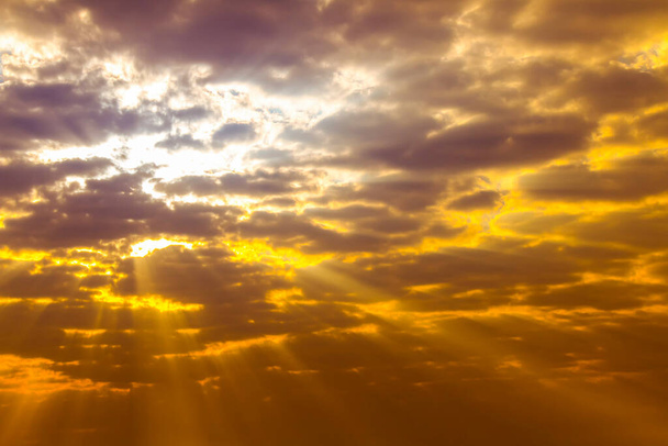 Explosief van zonlicht in oranje en gele wolken met bewolkte hemel - Foto, afbeelding